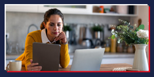 Woman staring at a laptop and digital pad