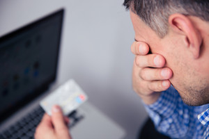 Man holding his face after viewing his credit score